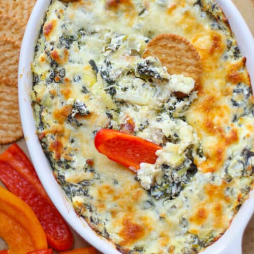 An overhead shot of the spinach dip with cracker and bell peppers.