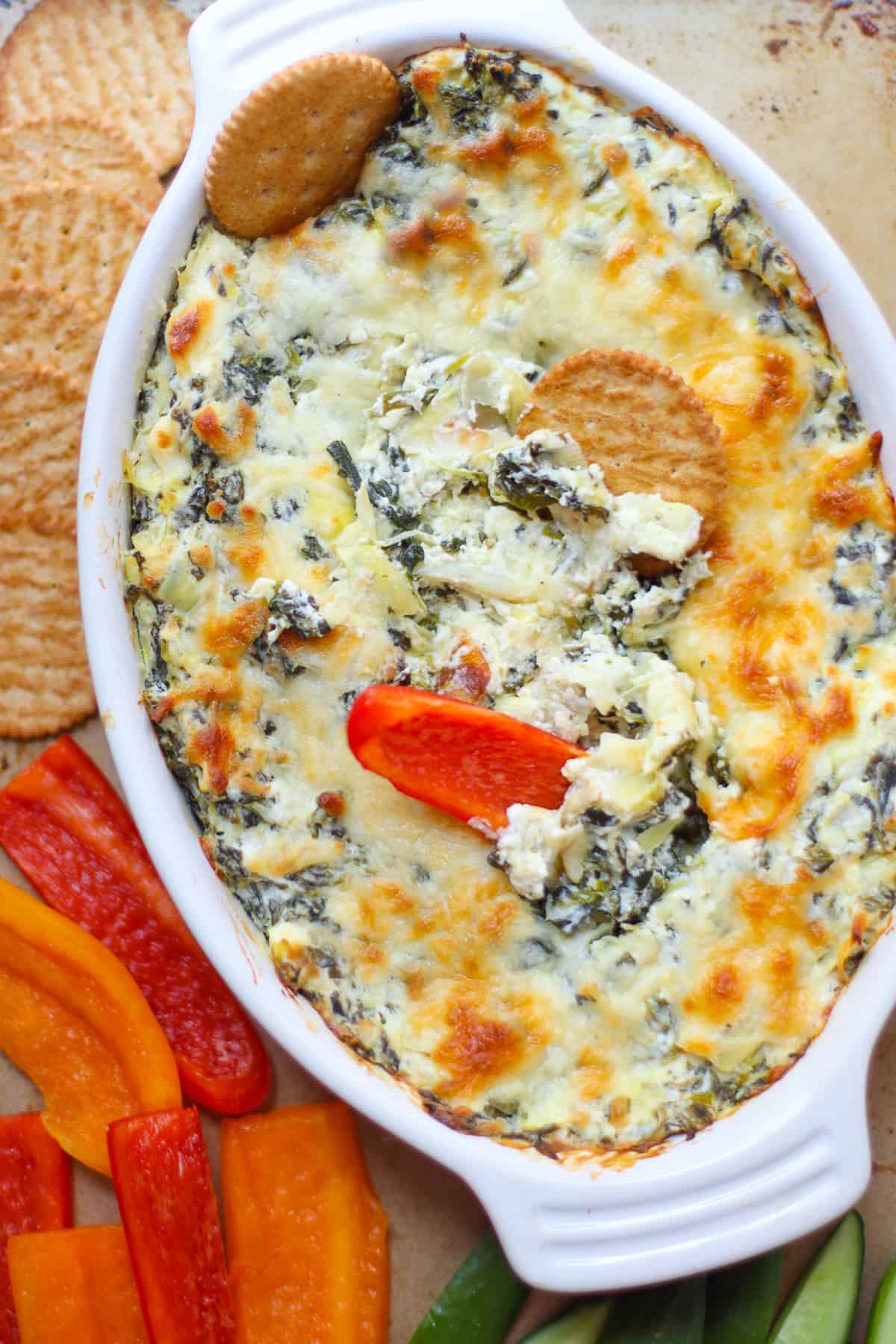An overhead shot of the spinach dip with cracker and bell peppers.