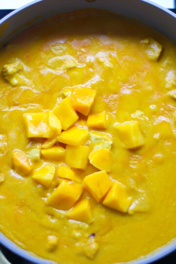 The remaining pieces of mango added to the chicken cooked in the curry sauce.