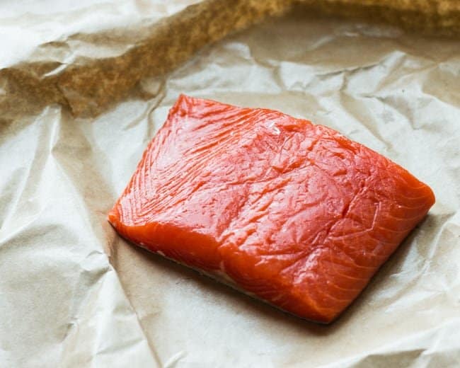 fresh uncooked wild caught salmon on parchment paper