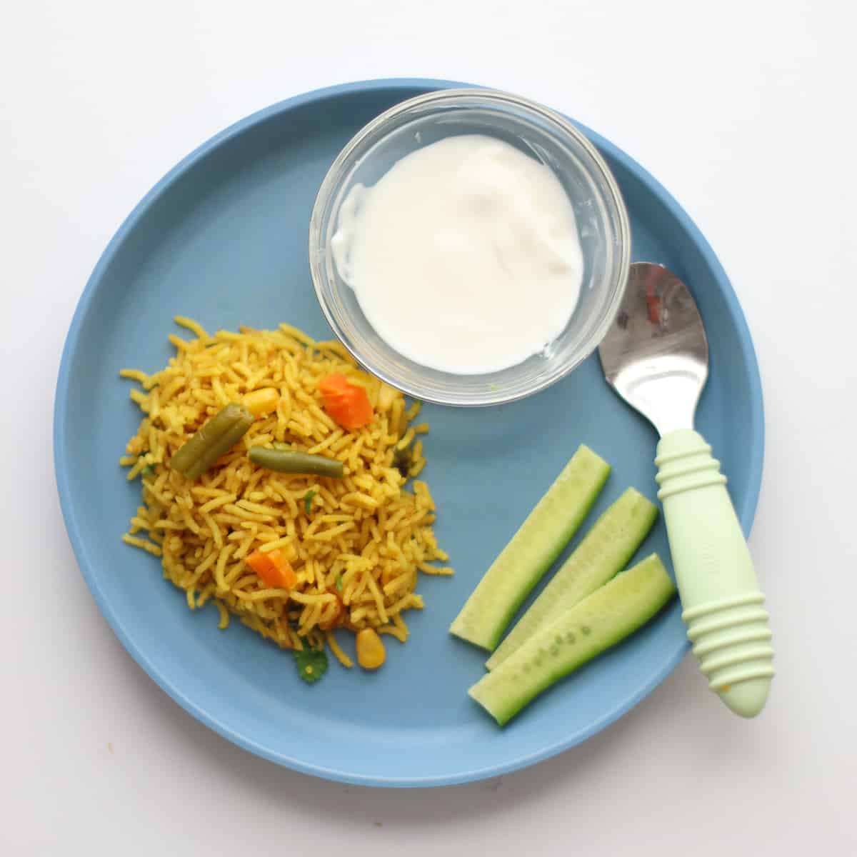 Toddler's plate with rice, yogurt, and cucumbers.