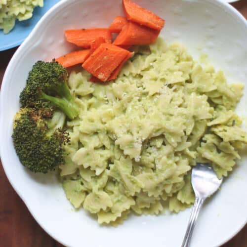 A close up shot of pasta with broccoli and carrots.