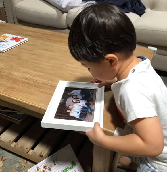 picture of toddler staring at family picture