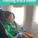 toddler sitting on a carseat on the airplane