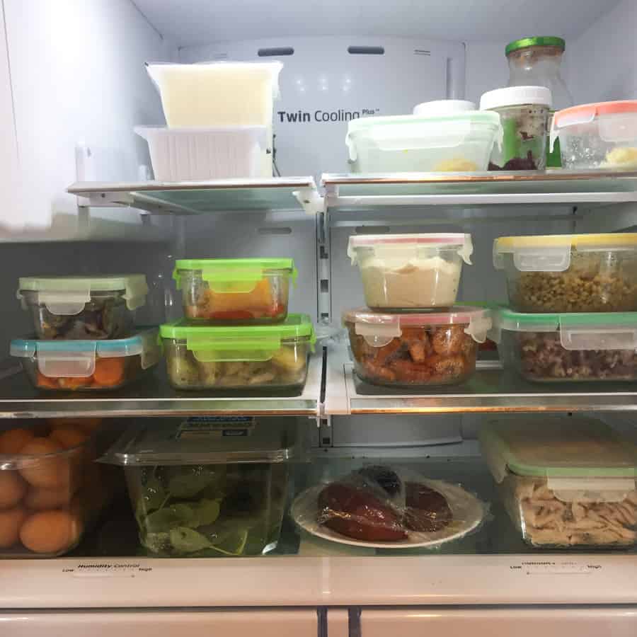 inside of a refrigerator with stacked glass containers filled with leftovers