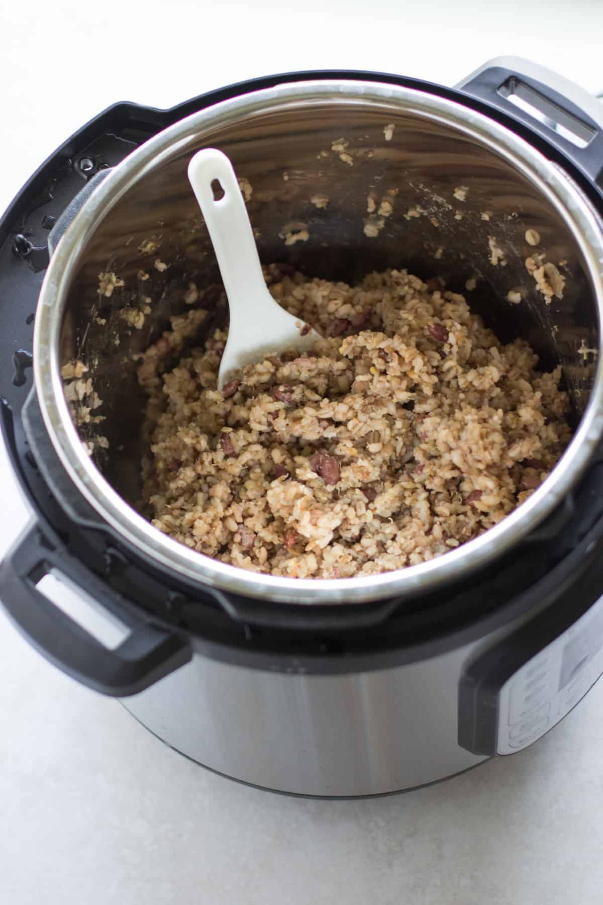 cooked multigrain rice inside the Instant pot with a spatula