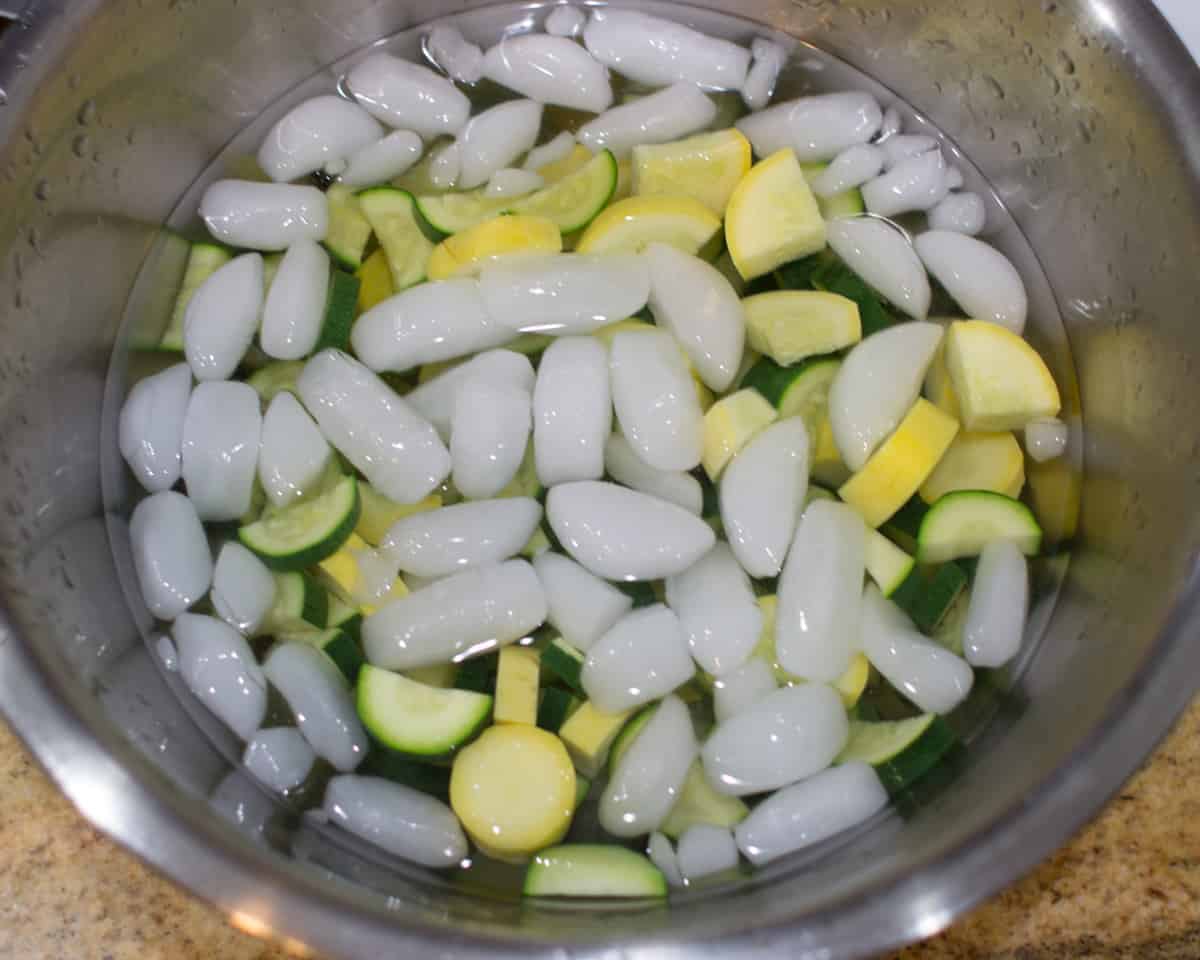 zucchini submerged in a large bowl with ice and water
