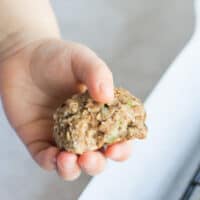 a toddler hand holding the zucchini bread cookie