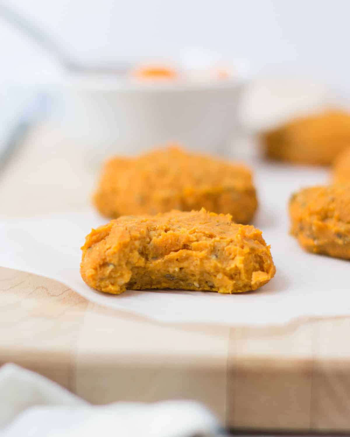 a close up shot of the sweet potato cookies with a bite taken out of it