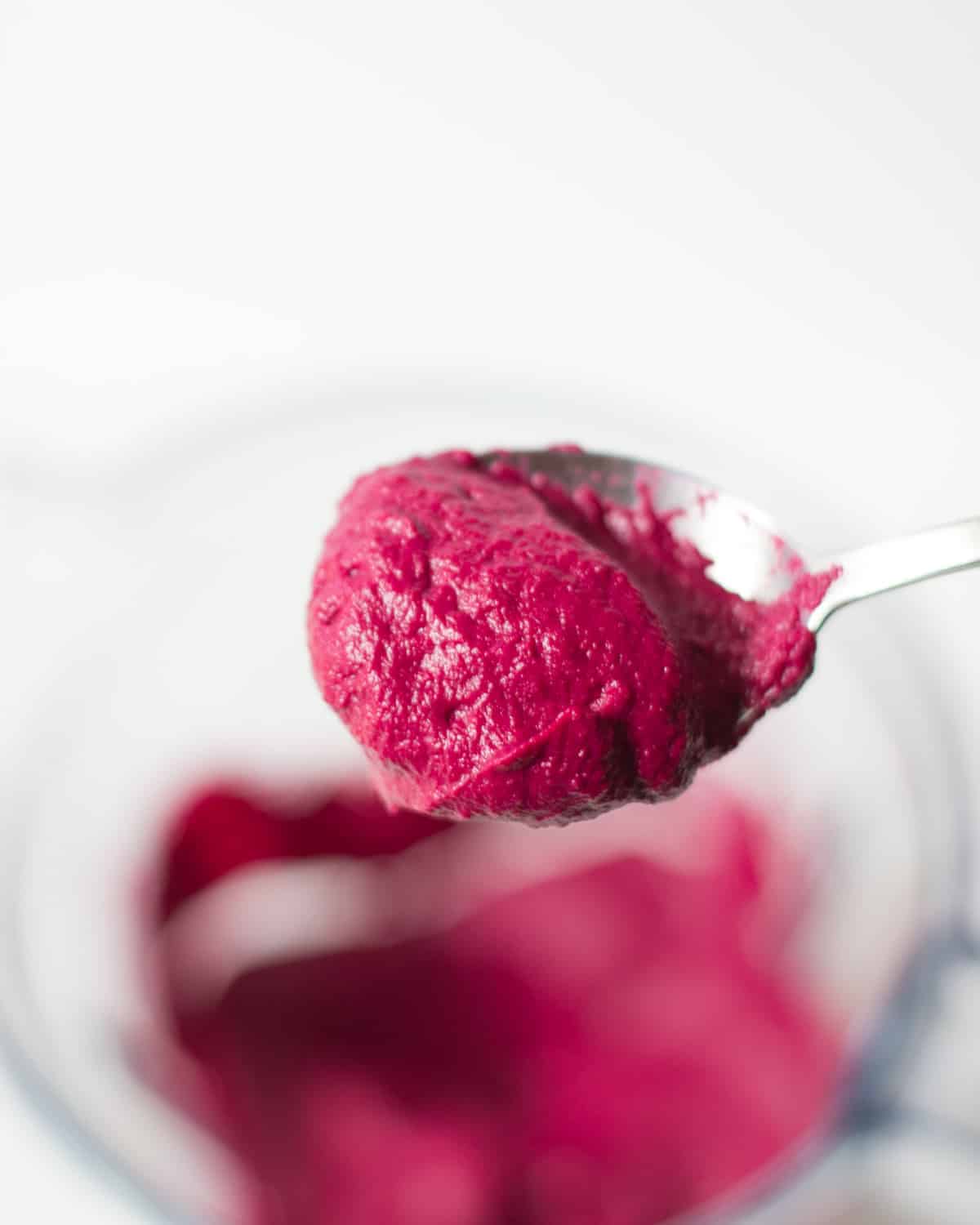 a close up shot of the spoon with beetroot dip