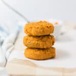 three sweet potato cookies for babies stacked on a wooden board