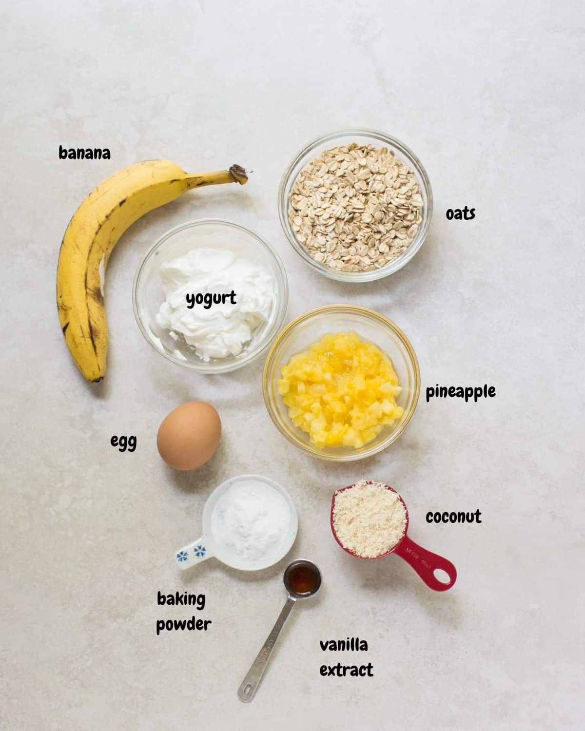 all the ingredients to make the pineapple coconut muffins laid out on a white background