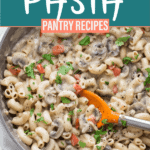 cooked creamy mushroom pasta in a large skillet with an orange spatula
