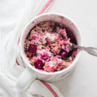 beetroot curry oatmeal served in a mug with a spoon