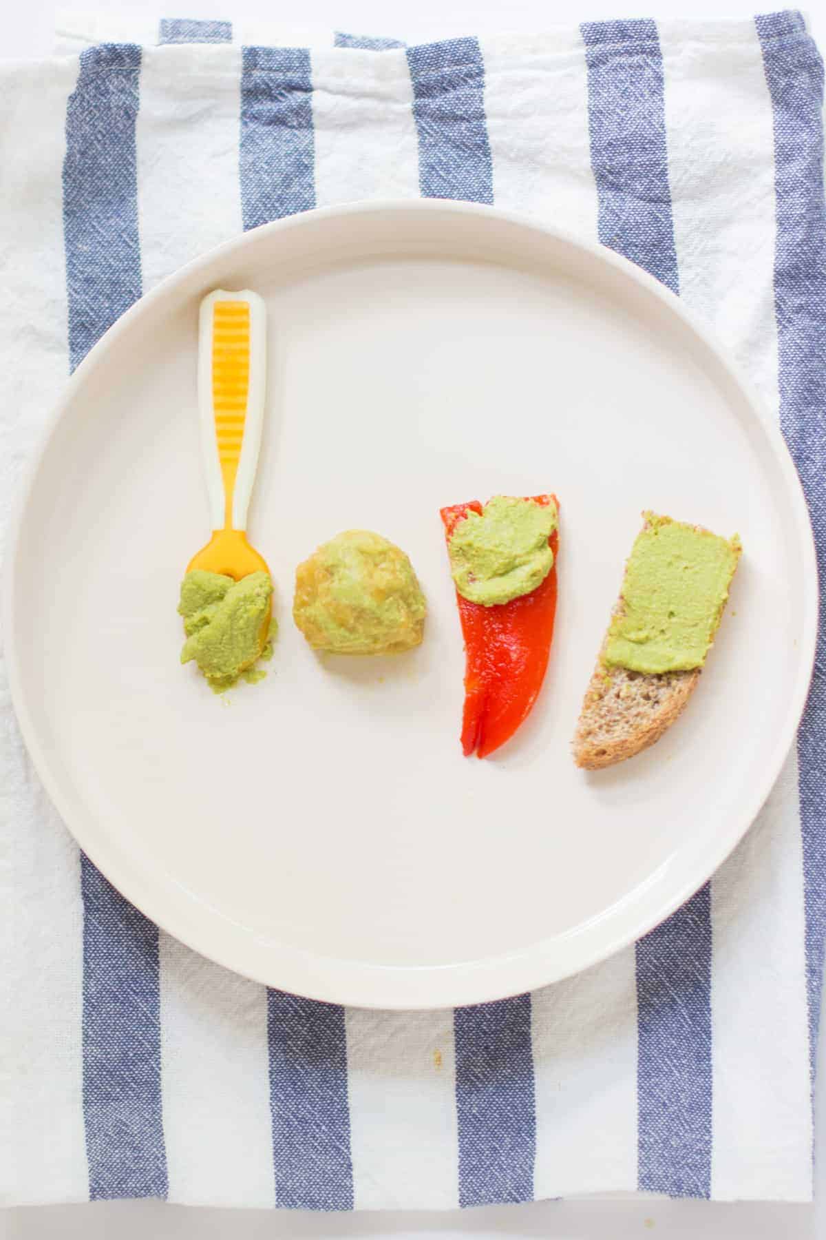 pumpkin seed spinach hummus served 4 ways - preloaded onto spoon, mixed with red lentils, spread on tip of red bell pepper and toasted bread