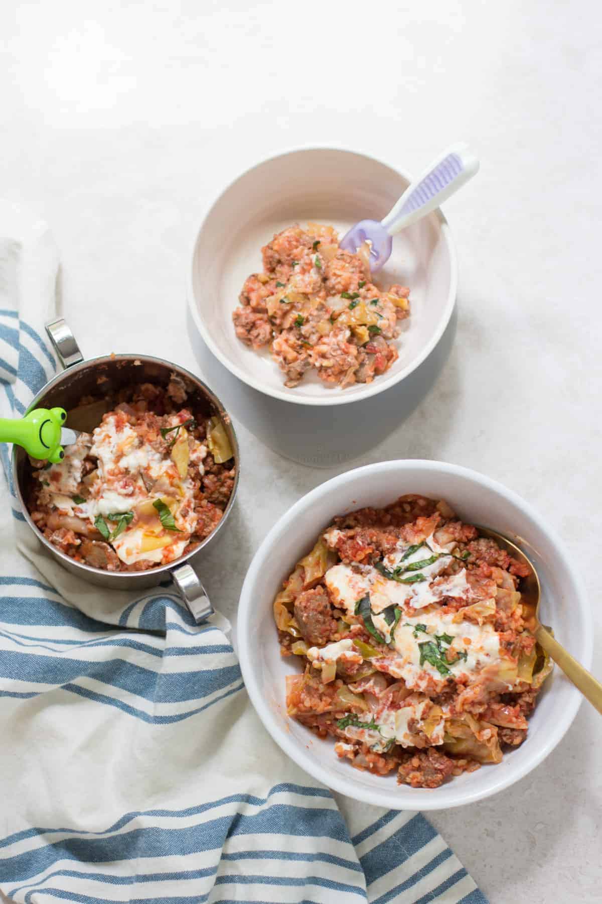 three bowls with lasagna. One for mom, toddler, and baby