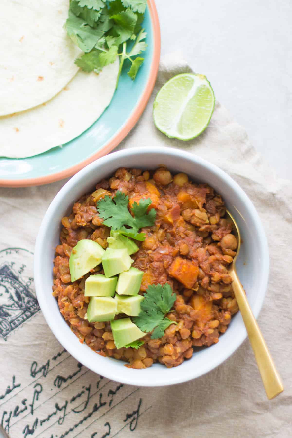 a bowl of slow cooker chickpea lentil chili with diced avocado and cilantro
