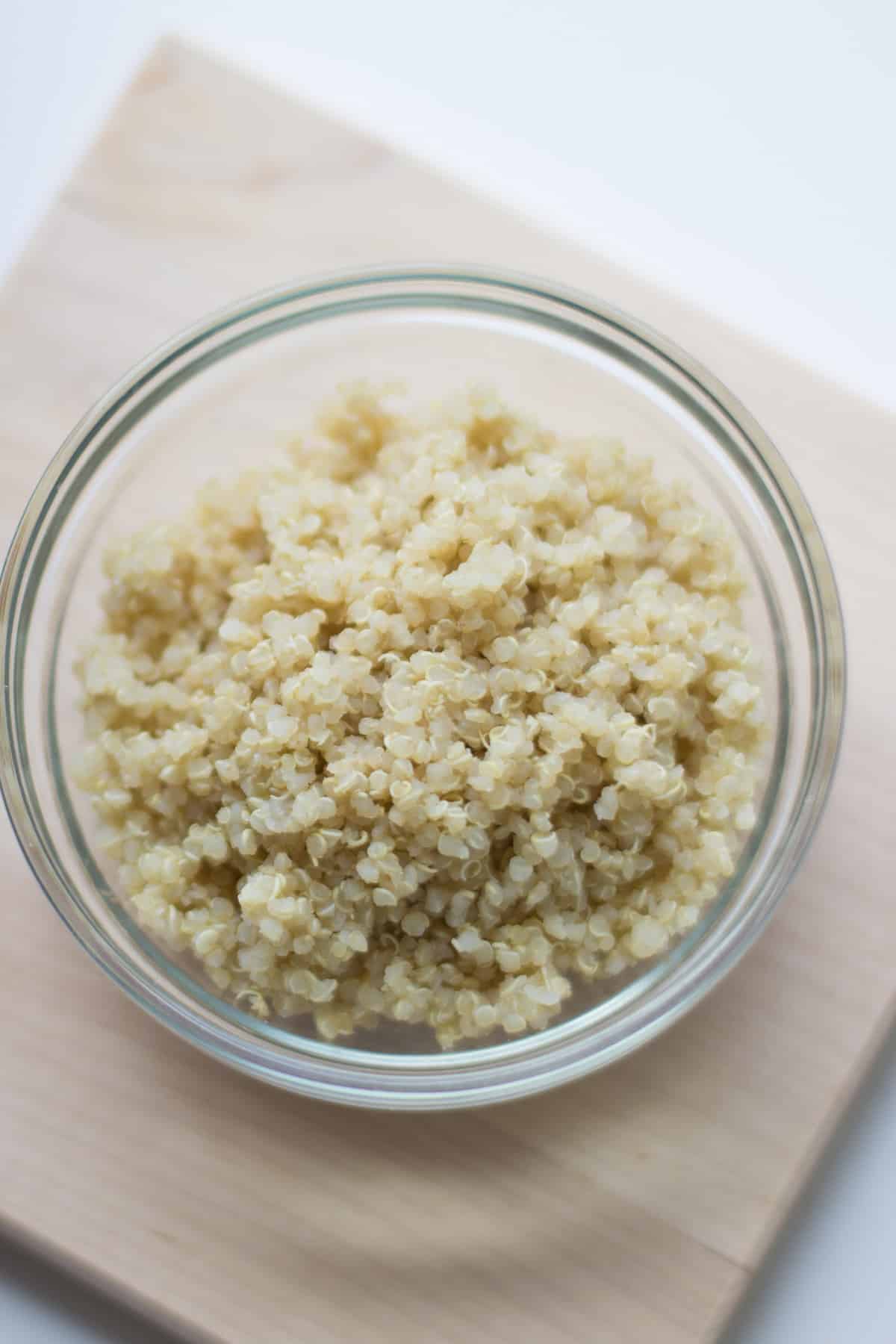 a close up shot of cooked quinoa in a glass bowl.