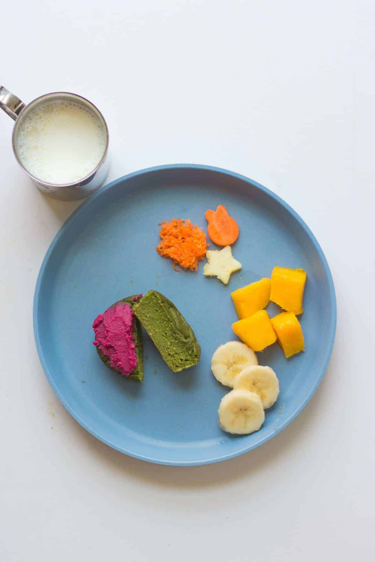 spinach muffin served with beet hummus, carrots, zucchini, mangoes, and bananas.