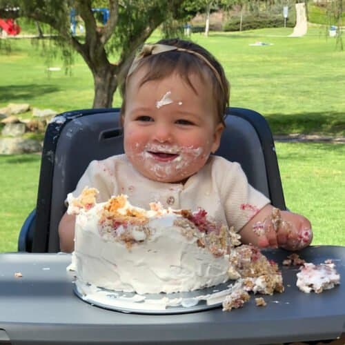 baby happily smashing the cake.