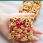 a square cereal bar placed on toddler's palm.