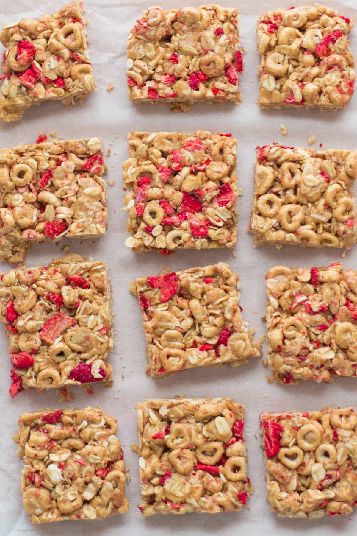a close up shot of sliced peanut butter cereal bars with strawberries.