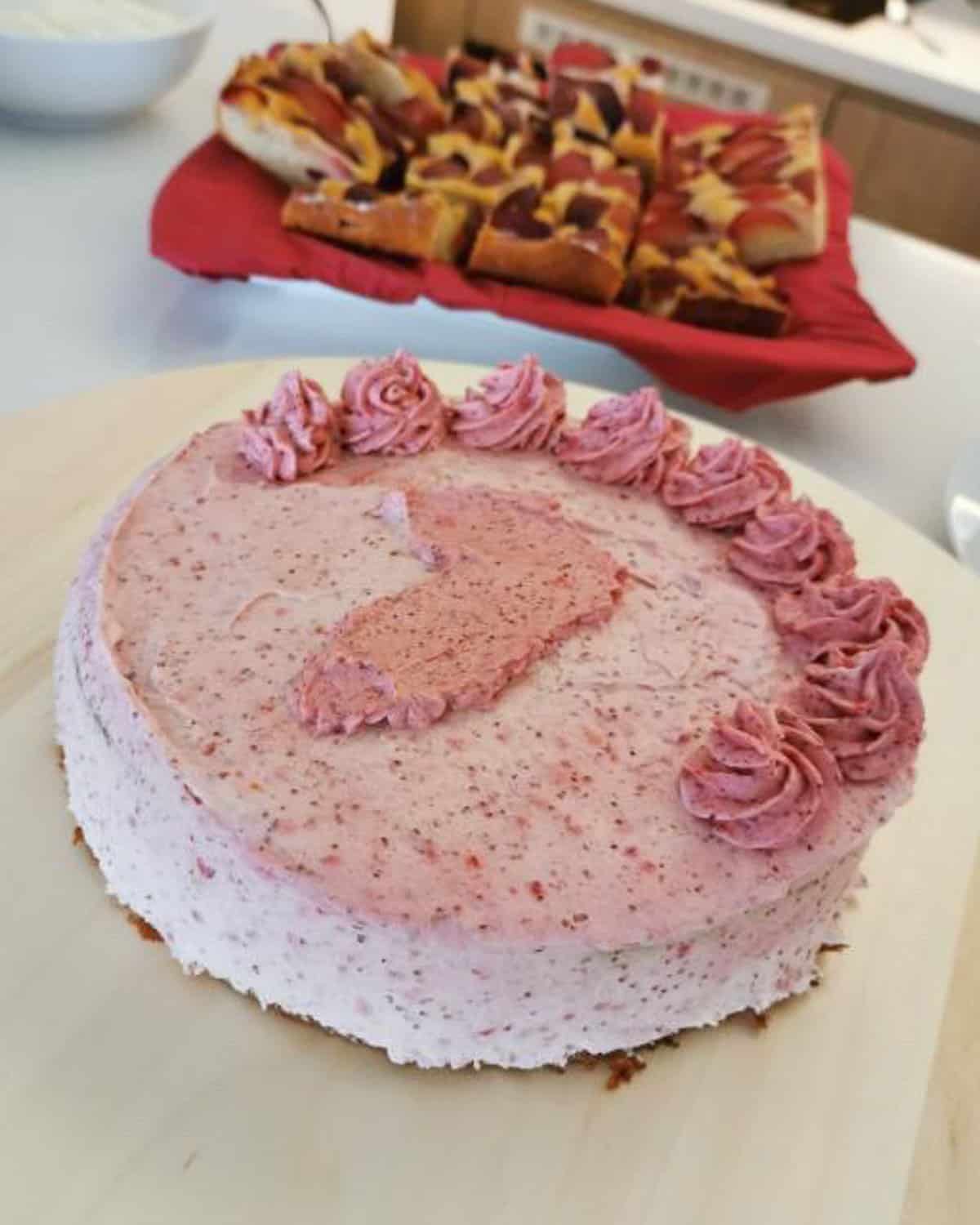 a large one layered pink frosted cake with number one.