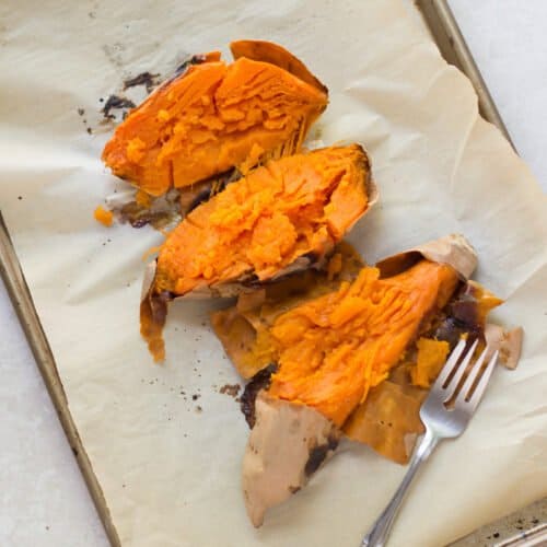 Three orange sweet potatoes roasted whole.