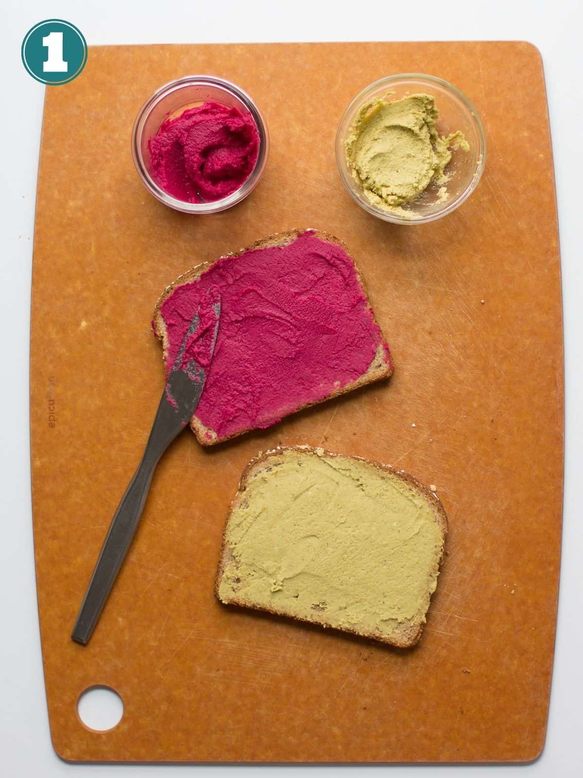 two pieces of bread, one with broccoli hummus and the other one with beet hummus.