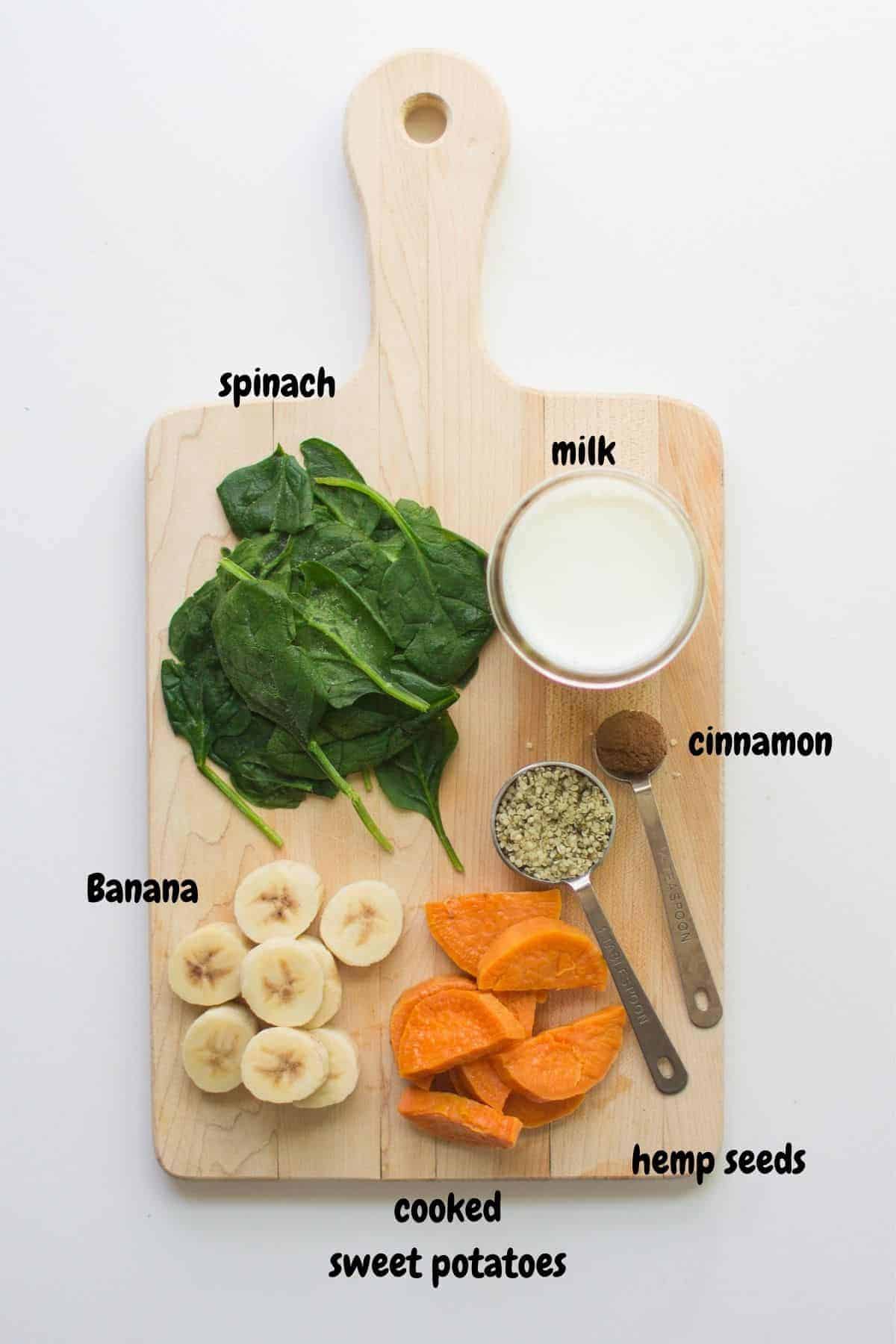 ingredients for sweet potato green smoothie laid out on a wooden board.