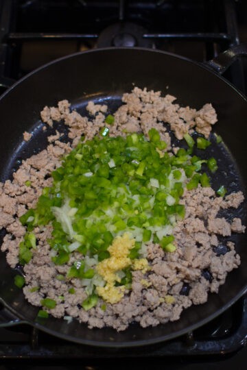 Cooked ground turkey in large skillet with vegetables added.
