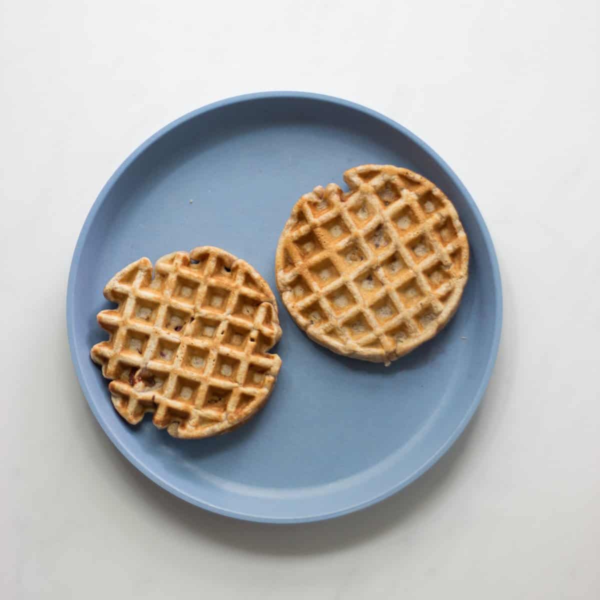 Two mini waffles on a blue plate.