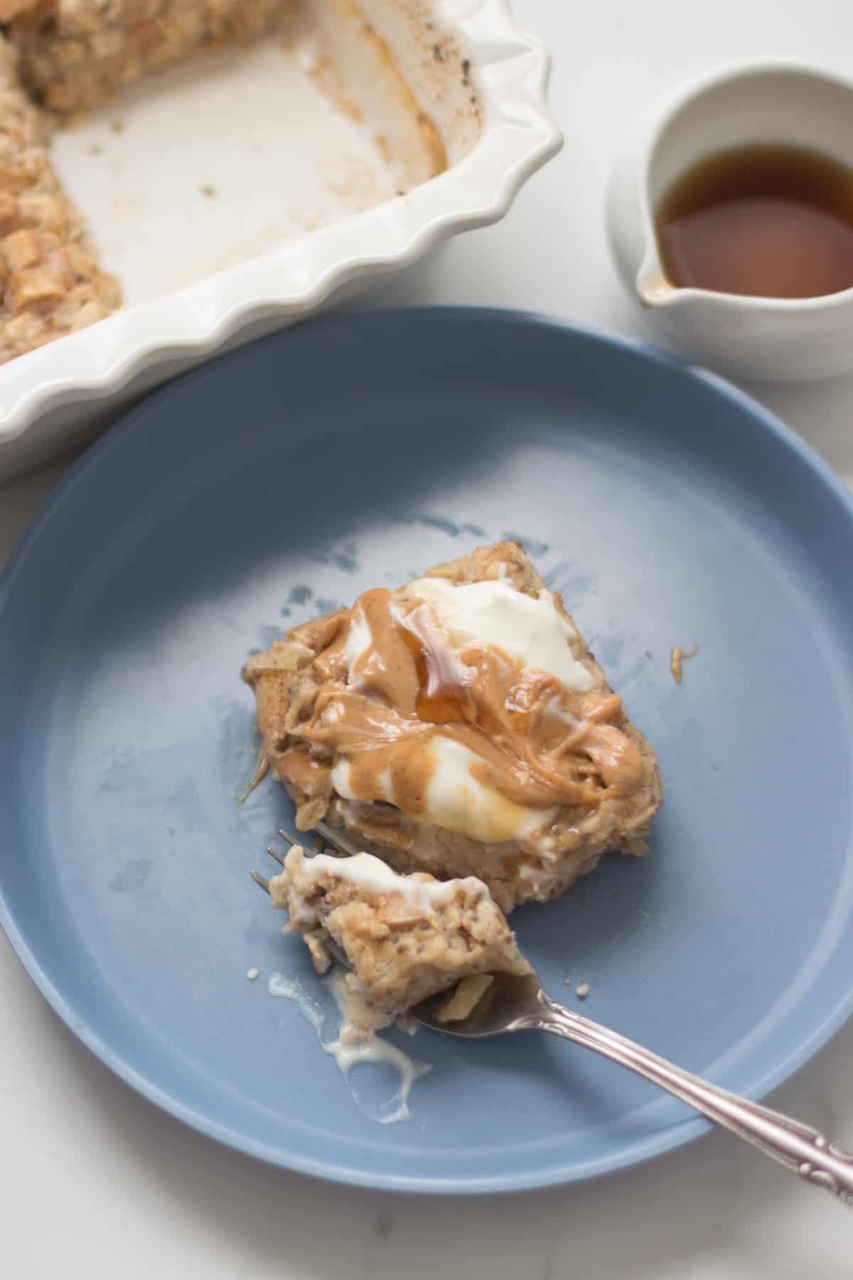 An oatmeal slice with yogurt, peanut butter, and maple syrup on top.