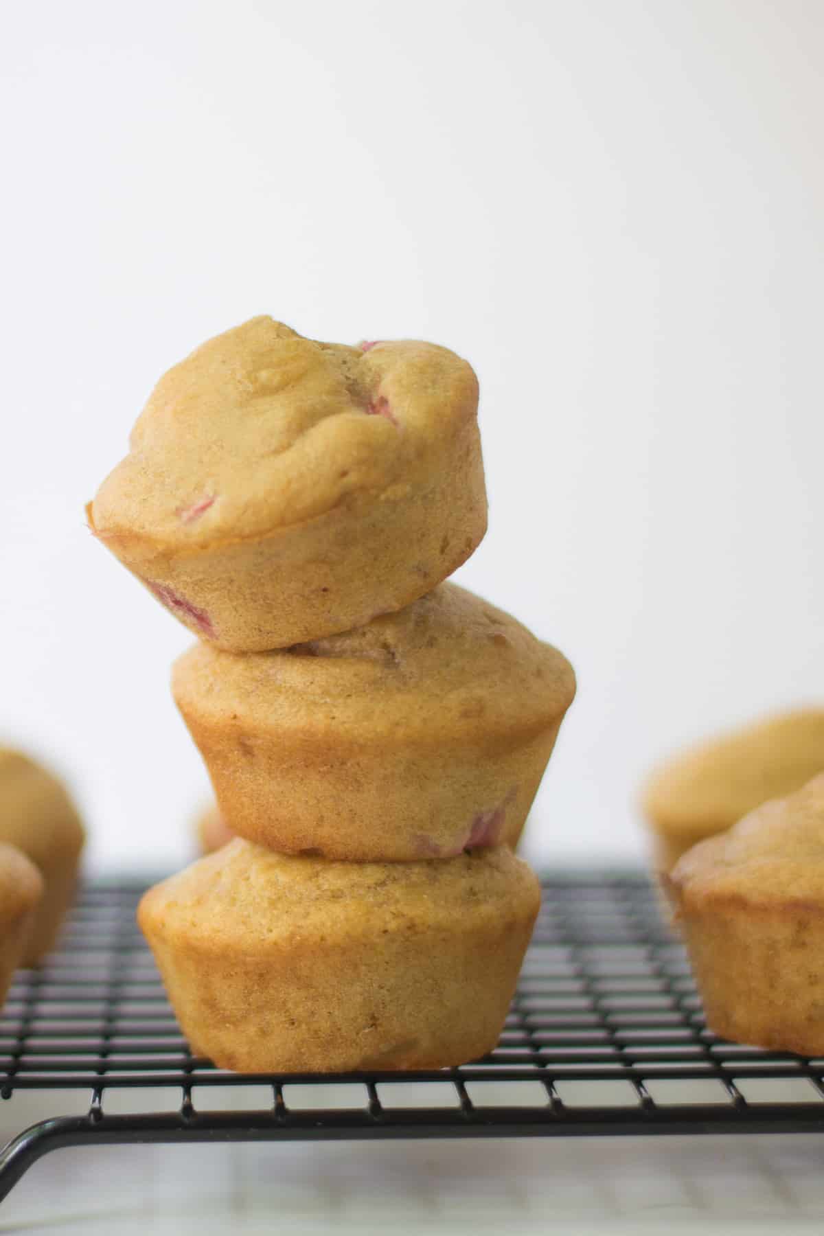 Three stacked yogurt muffins on a wire racck.