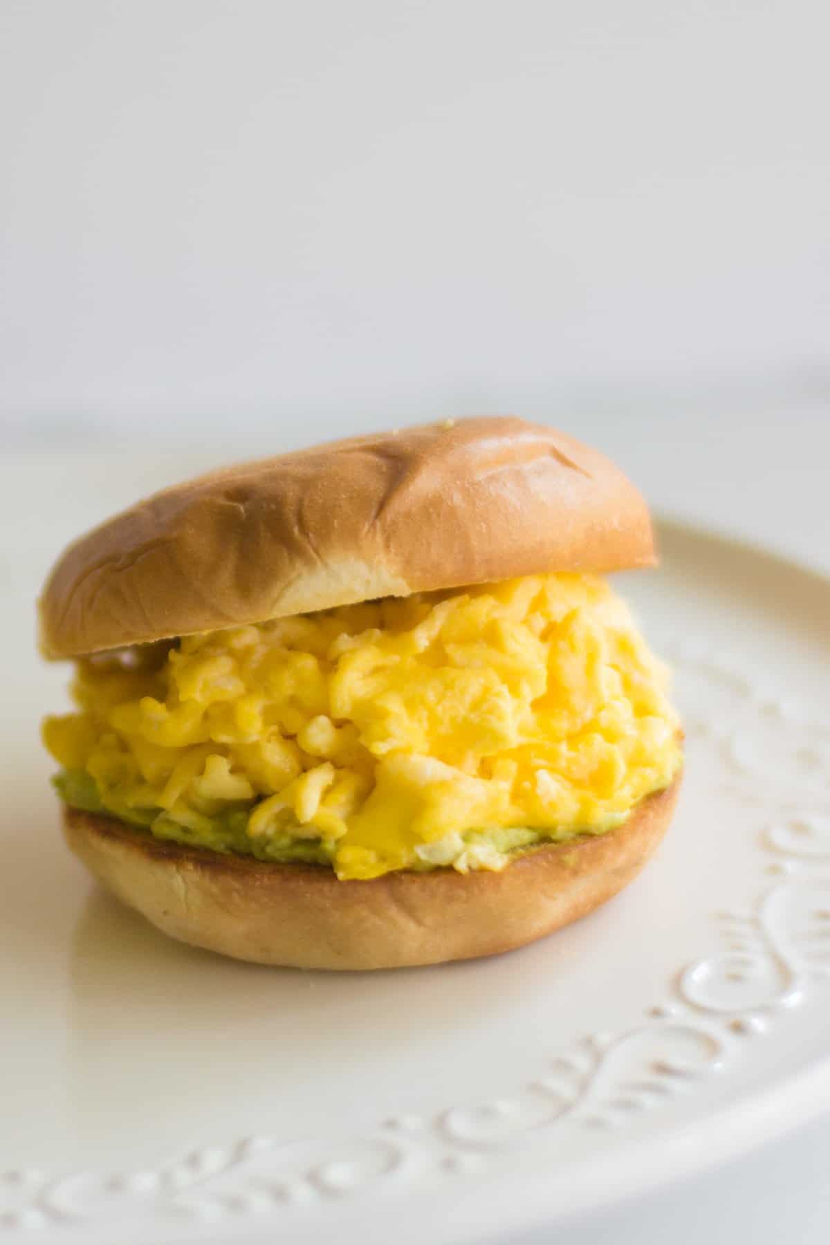 Scrambled eggs piled high between two slices of bread.