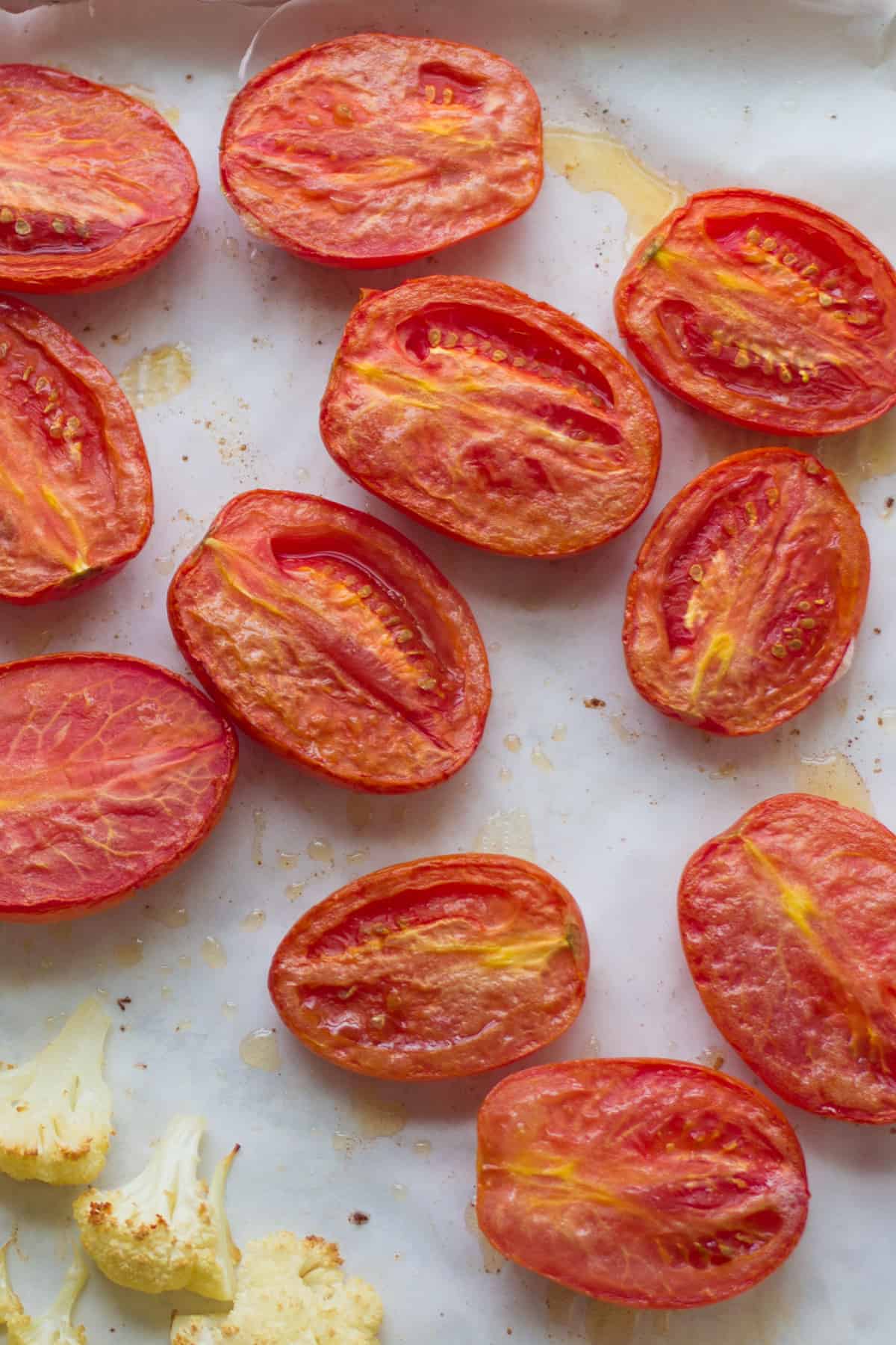 Roasted halved roma tomatoes cut side up.