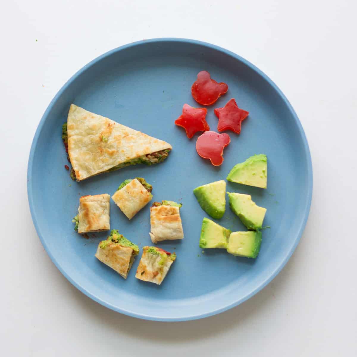 Sliced and bite sized quesadilla with avocado and cute shape bell peppers.