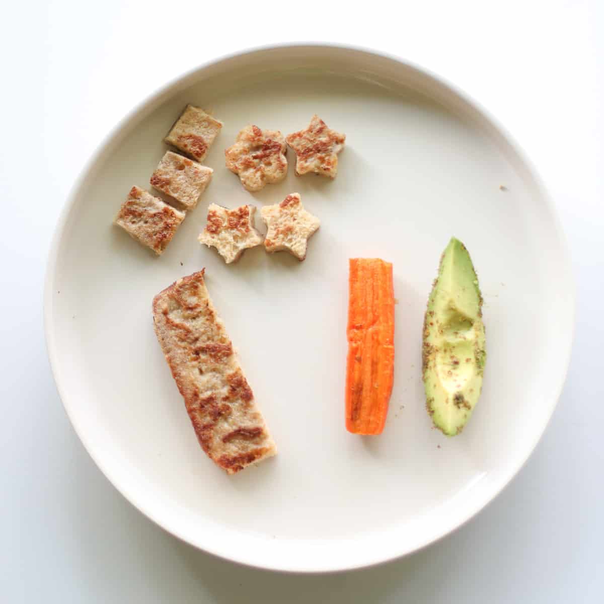 Banana French toast in strip and small pieces along with carrot and avocado.
