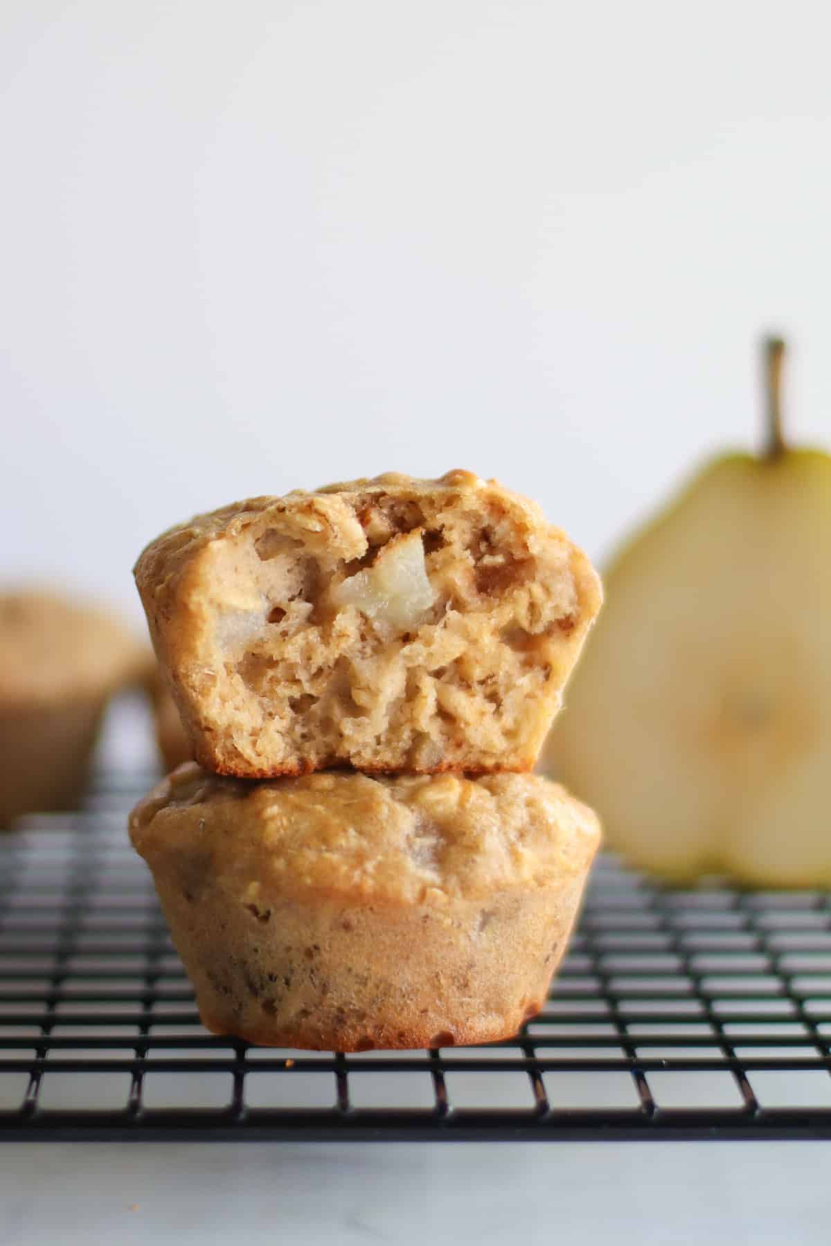 2 pear muffins stacked with a bite taken out of the top one.