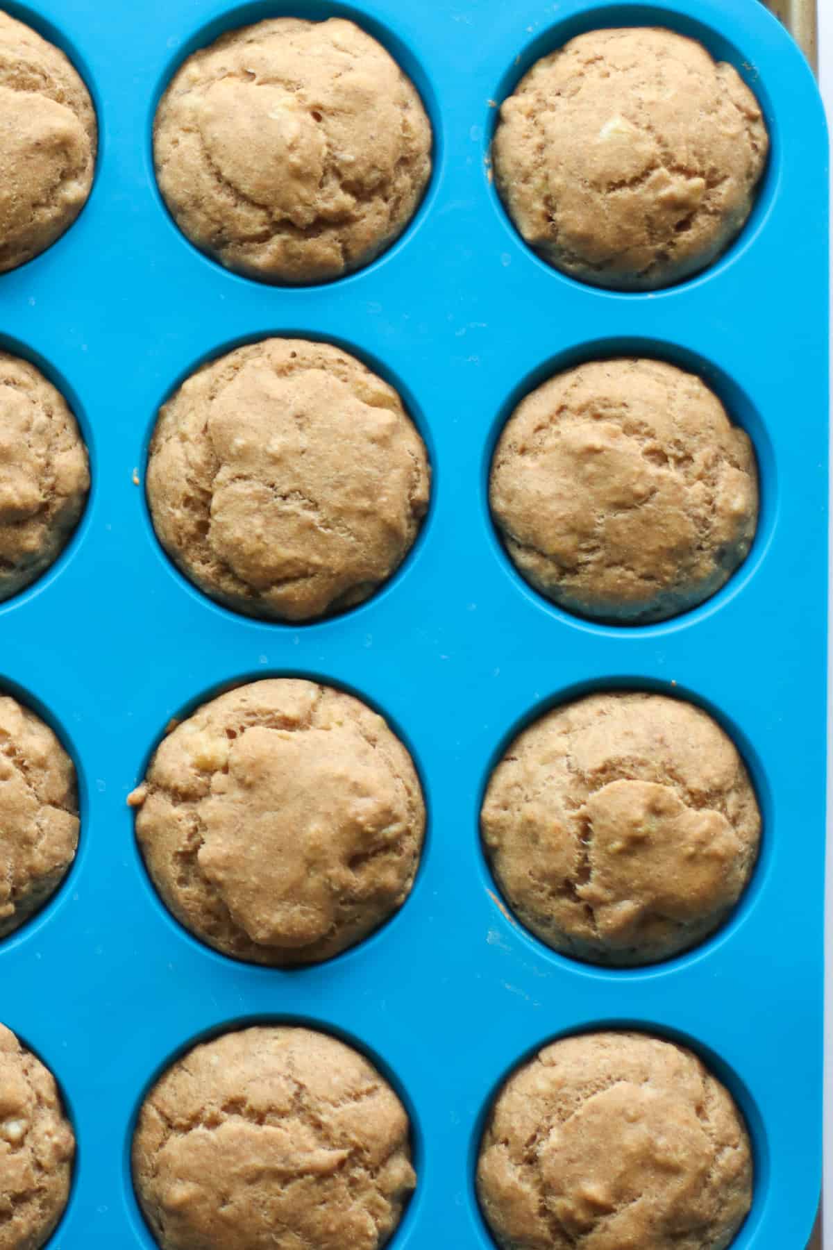 Baked muffins in a blue silicone muffin pan.
