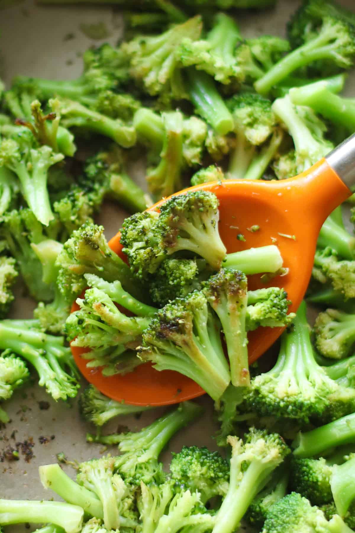 Browned sauteed frozen broccoli scooped with spatula.