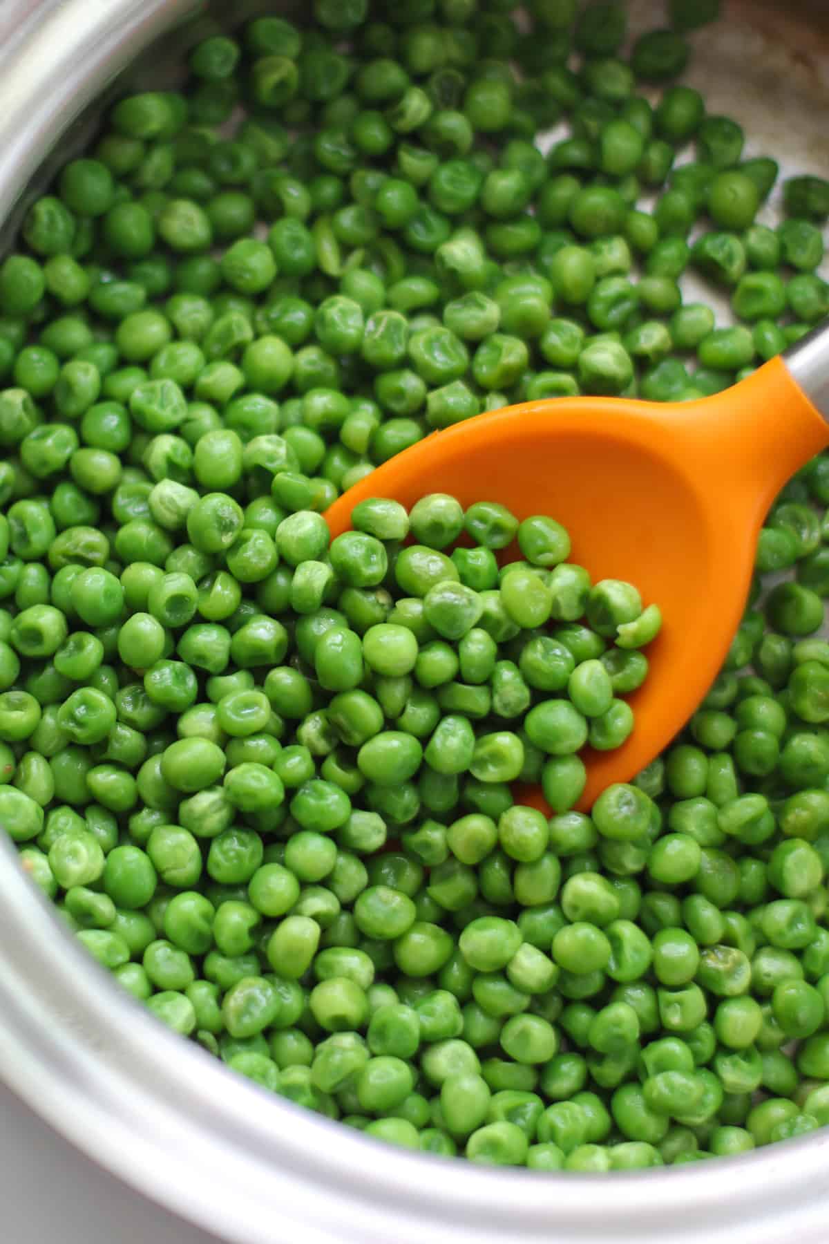 Sauteed frozen peas in a large skillet.