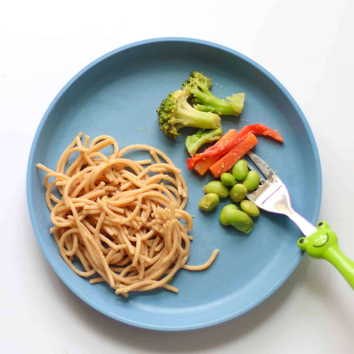 Toddler's plate with pasta and vegetables separated.