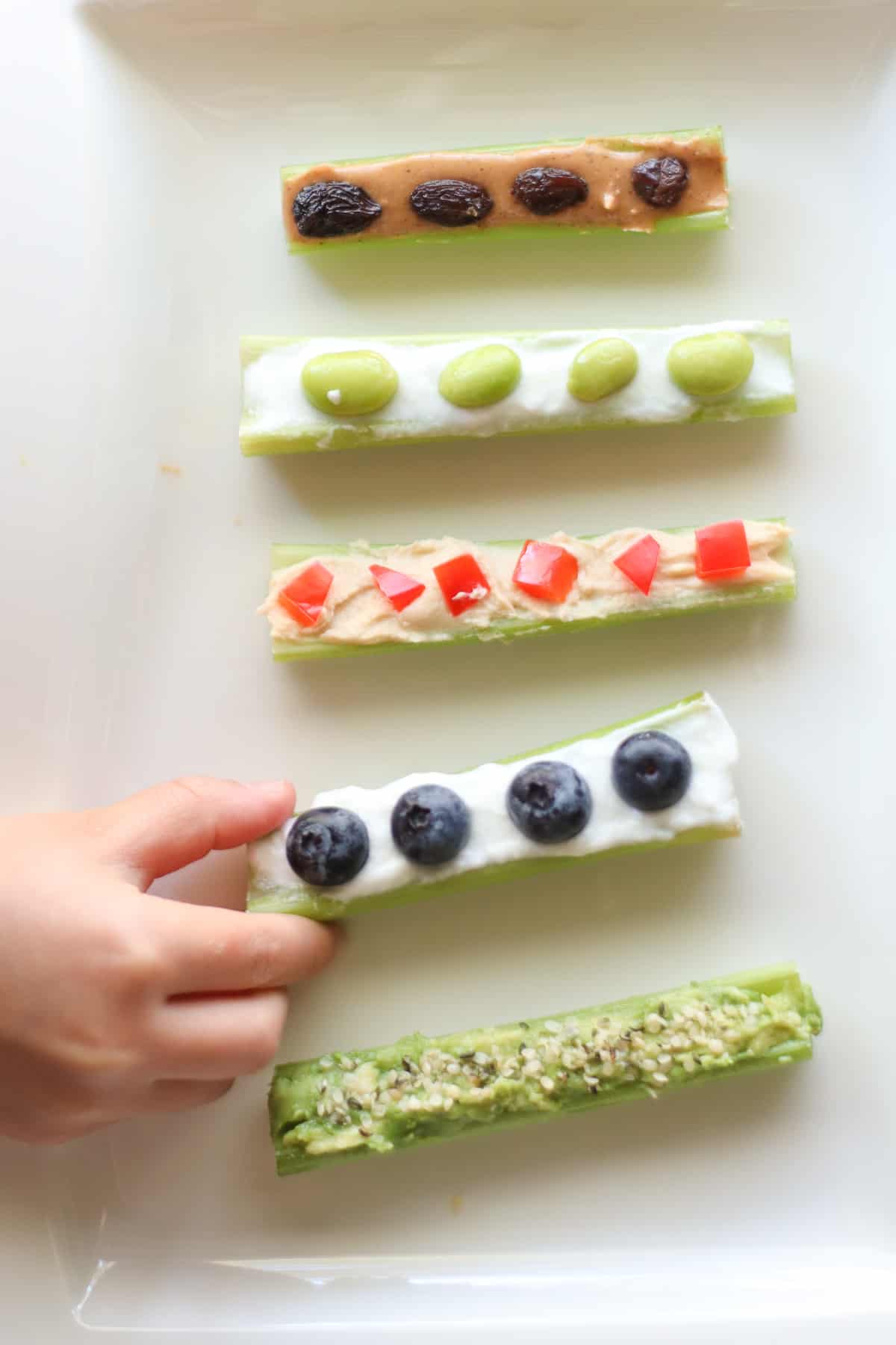 5 celery sticks with various fillings and toppings.