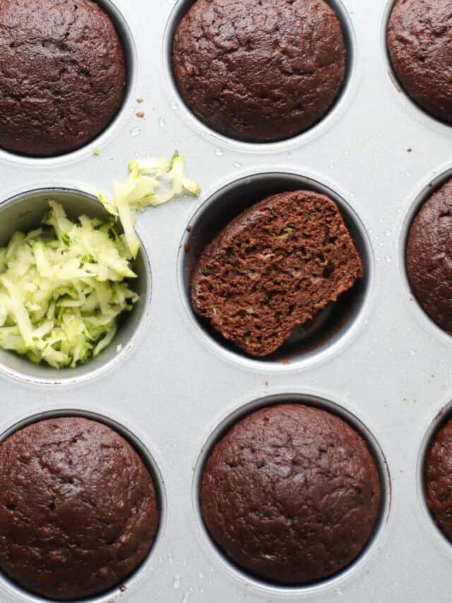 An overhead shot of muffins in a baking pan with shredded zucchini.