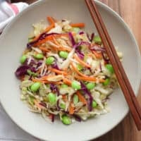Asian cabbage salad placed on a plate with chopsticks.