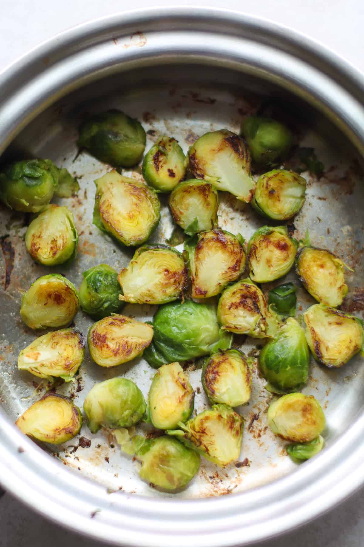 Sauteed frozen Brussels sprouts in a large pan.
