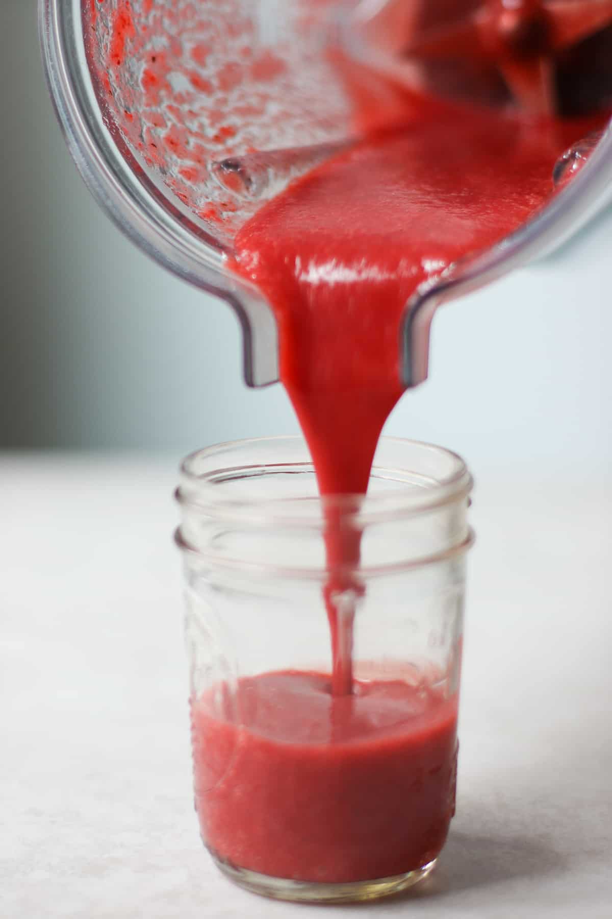 Strawberry juice being poured from blender.