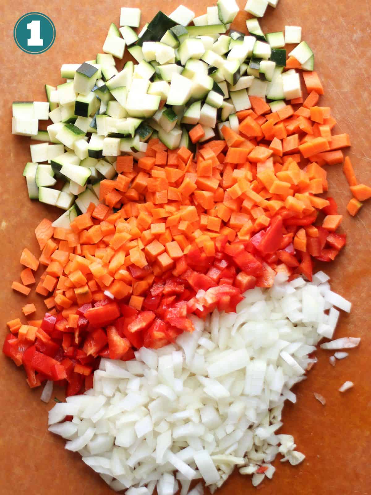 All the veggies chopped on a wooden board.