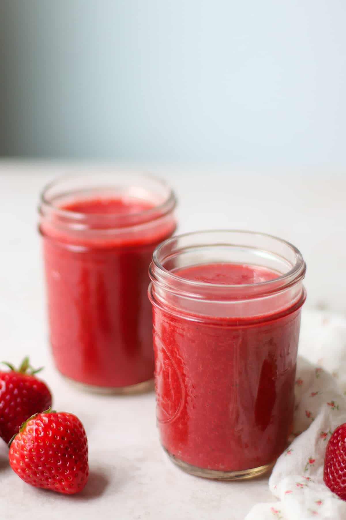 Two pint sized mason jars filled with juice.